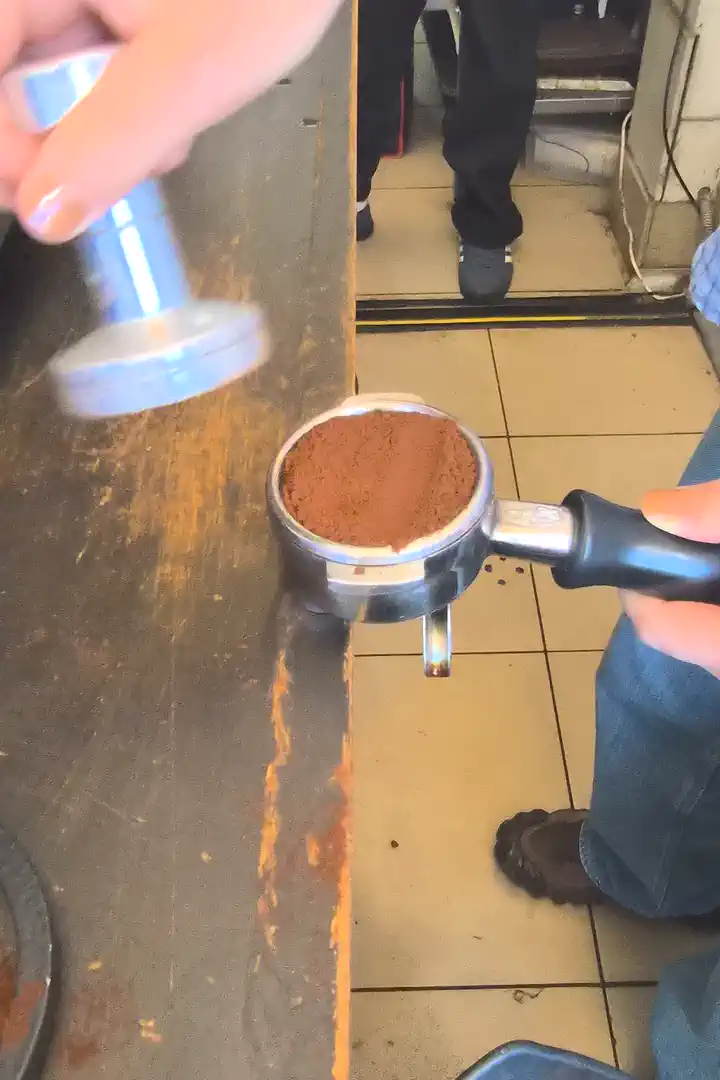 タンパーで粉を均一に押し固める様子